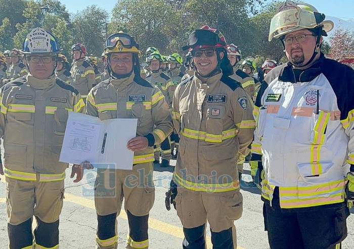 De izquierda a derecha, el superintendente de Bomberos San Felipe, David Guajardo, haciendo entrega de los documentos del nuevo carro para la Tercera Compañía.