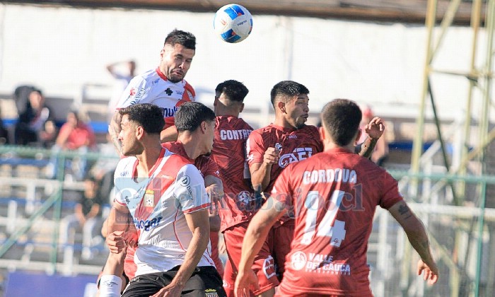 La zaga albirroja intenta ganar un balón aéreo a los curicanos.