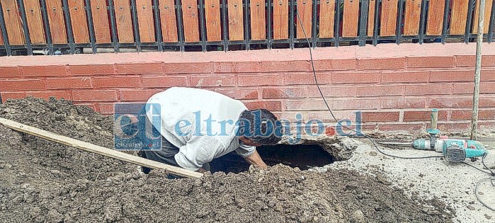 Teniendo que romper para poder arreglar. Se aprecian las herramientas y uno de los vecinos trabajando.