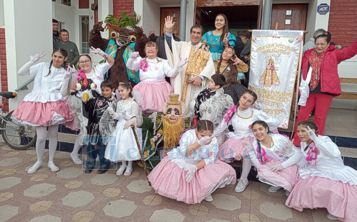Integrantes de Bailes Chinos junto al sacerdote.