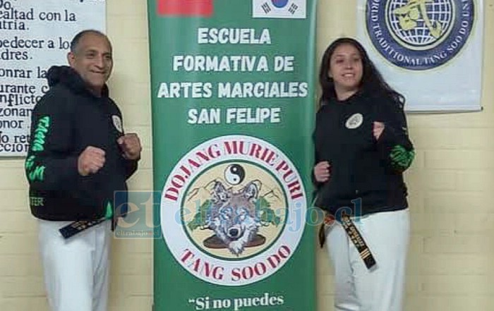 El maestro Jorge con el pendón de la escuela junto a su hija Javiera.