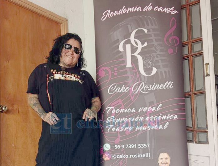 ‘Cako’ Rosinelli junto al flayer de su academia de canto.