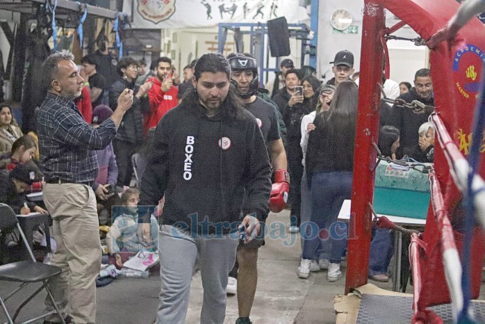 Junto con uno de sus pupilos camino al ring.