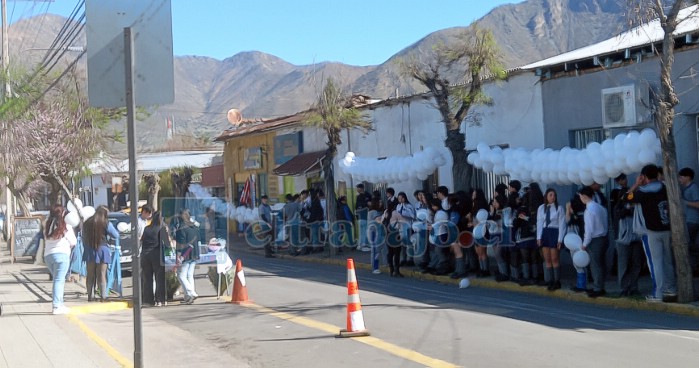 Comunidad educativa esperando por la carroza fúnebre, para despedir al docente.