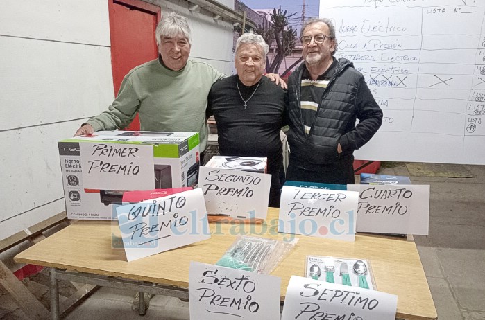 La directiva, encabezada por Manuel Bustamante, junto a los premios que se rifaron.