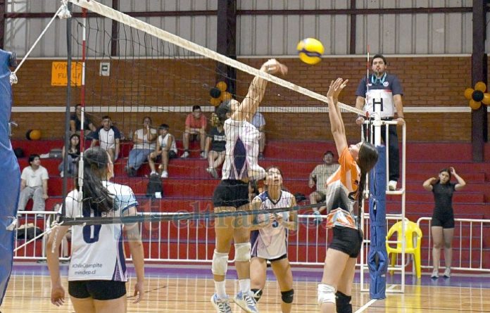 Jugadora intenta bloquear el tiro de su rival.