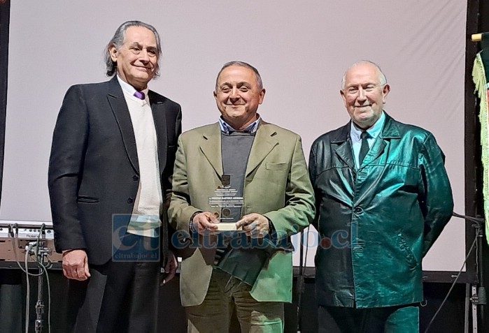 El exalumno destacado en este aniversario Cristian Martínez Ahumada, recibe su distinción de manos de José Plaza A. y Erik Rivadeneira B., hijo del recordado profesor.