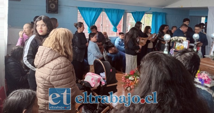 Un pastor evangélico realizando el responso acompañado de su coro y músicos.