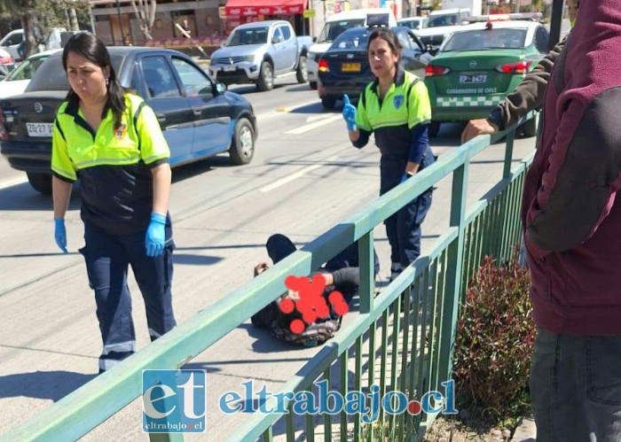 El motociclista en el suelo y personal del SAMU y Carabineros a su lado.