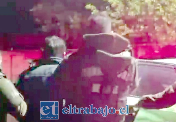 El detenido siendo conducido por Carabineros la noche de su detención.