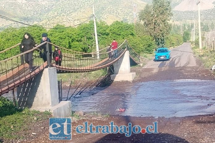 Los estudiantes pasando por el recién construido puente en El Naranjal, Catemu.