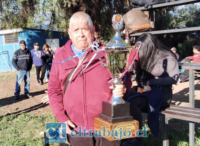 Luis Alberto Reinoso abrazando una copa.